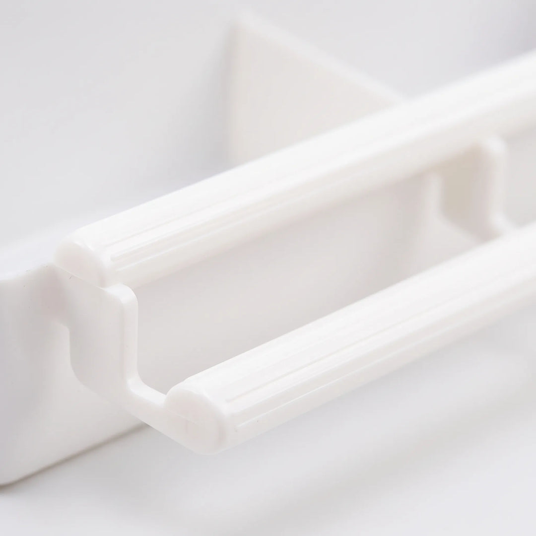 Close-up of the feeder's two ribbed white plastic perch bars and their connecting bracket on the front of the tray. 3