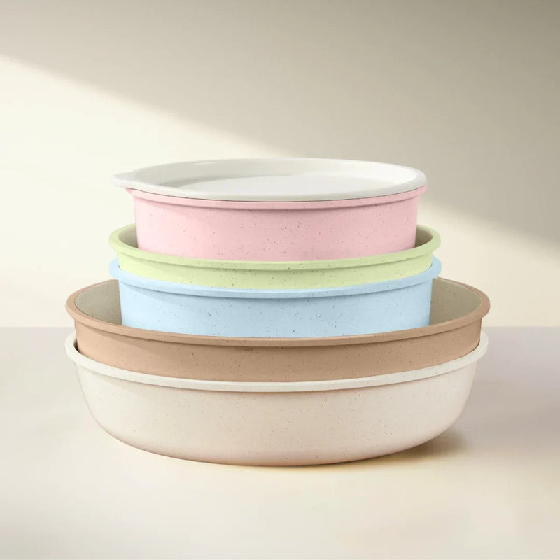Pastel pink, green, blue, beige and cream pans nested together in a neat stack, the pink one topped with a lid 3