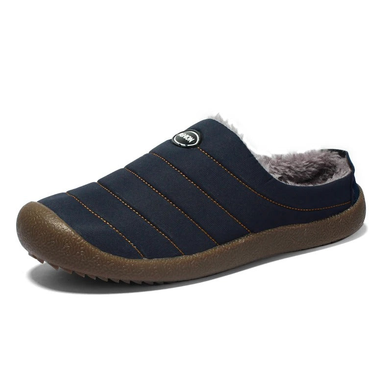 Single navy blue quilted slipper on white, showing fleece lining and chunky brown sole 15